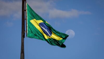 Bandeira do Brasil hasteada no mastro da Praça dos Três Poderes, tendo a lua ao fundo | Sérgio Lima/Poder360 11.jul.2022