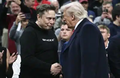 Tesla and SPaceX CEO Elon Musk and US President Donald Trump shake hands as they attend the men's NCAA wrestling competition at the Wells Fargo Center in Philadelphia, Pennsylvania, on March 22, 2025. (Photo by Brendan SMIALOWSKI / AFP) / ALTERNATE CROP