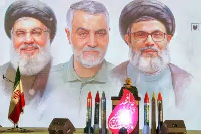 RGC commander-in-chief Major General Hossein Salami speaks during a memorial service beneath portraits of slain Hezbollah leader Hasssan Nasrallah (L) Iranian general Qassem Soleimani (C), and Nasrallah's successor Hashem Safieddine at Tehran's Grand Mosque in Iran's capital Tehran on February 23, 2025. Iran's supreme leader Ayatollah Ali Khamenei vowed 