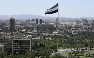 A large Syrian flag flutters above Tishreen Park in Damascus on June 4, 2025. Syria's interim President Ahmed al-Sharaa has in six months established himself internationally and had crippling sanctions removed, but still needs to rebuild national institutions, revive the economy and unite the fractured country. (Photo by LOUAI BESHARA / AFP)