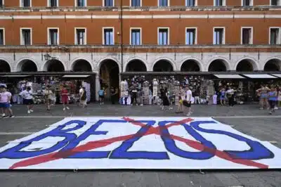 People gather to protest against the wedding of Amazon Founder and CEO Jeff Bezos and journalist Lauren Sanchez in Venice, on June 13, 2025. Poster campaigns and stickers have spread throughout the city, including one with images of Bezos reading 