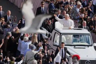 A bird flies by as Pope Leo XIV on his popemobile tours St. Peters Square at the Vatican prior to the inaugural Mass of his pontifcate, Sunday, May 18, 2025. (Photo by Jacquelyn Martin / POOL / AFP)