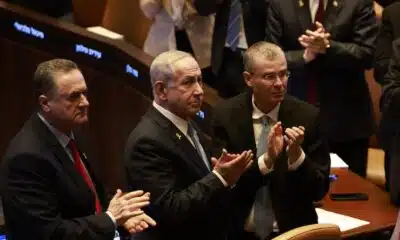 (L to R) Israel's Defence Minister Yisrael Katz, Prime Minister Benjamin Netanyahu, and Justice Minister Yariv Levin applaud Argentina's President as the latter attends a session of the Israeli parliament at the Knesset headquarters in Jerusalem on June 11, 2025. (Photo by Menahem KAHANA / AFP)