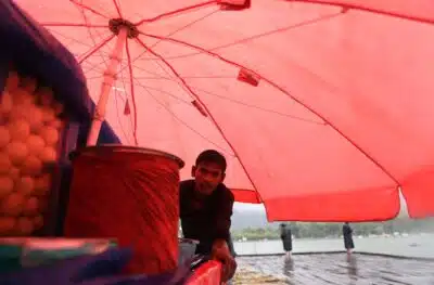 SRINAGAR (India), 14/08/2025.- A roadside vendor takes shelter under his carts umbrella during rainfall in Srinagar, India, 14 August 2025. A cloudburst struck a remote mountain village in Jammu and Kashmirs Kishtwar district, killing at least 38 people including two policemen, officials said. EFE/EPA/FAROOQ KHAN