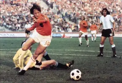 Dutch midfielder Johann Cruyff dribbles past Argentinian goalkeeper Daniel Carnevali on his way to scoring a goal during the World Cup quarterfinal soccer match between the Netherlands and Argentina on June, 26, 1974 in Gelsenkirchen. Cruyff scored two goals to help the Netherlands defeat Argentina 4-0.        AFP PHOTO (Photo by AFP)
