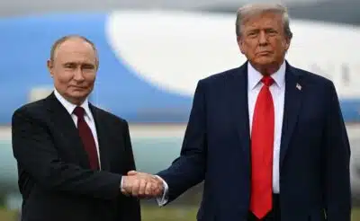 US President Donald Trump (R) and Russian President Vladimir Putin shake hands as they pose on a podium on the tarmac after arrival at Joint Base Elmendorf-Richardson in Anchorage, Alaska, on August 15, 2025. Putin is in Alaska at the invitation of Trump in his first visit to a Western country since he ordered the 2022 invasion of Ukraine that has killed tens of thousands of people. (Photo by ANDREW CABALLERO-REYNOLDS / AFP)