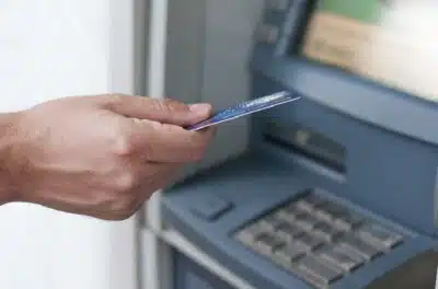 Hand inserting ATM card into bank machine to withdraw money. businessman men hand puts credit card into ATM